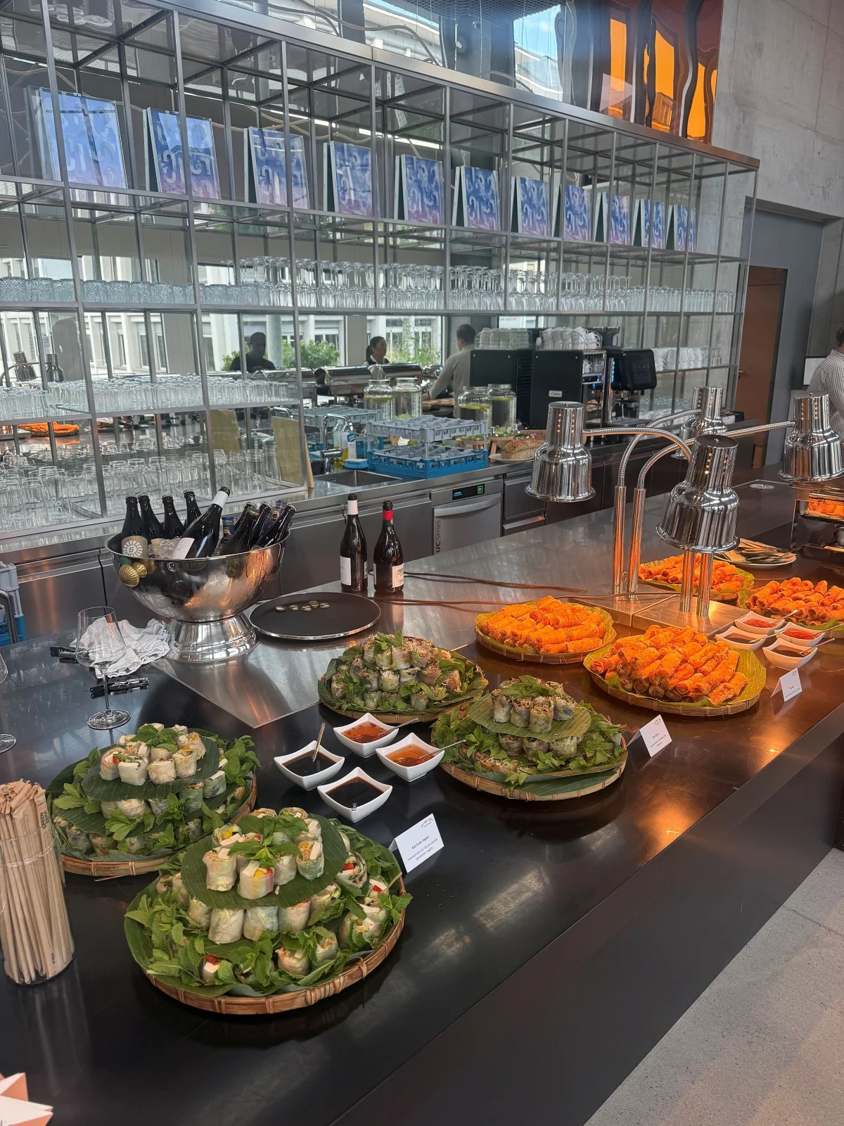 Catering appetizer spread with fresh spring rolls, dipping sauces, and plated hors d'oeuvres at restaurant buffet